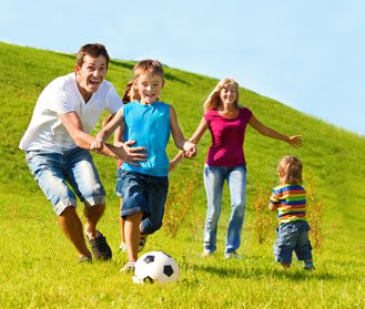 Happy family playing soccer together